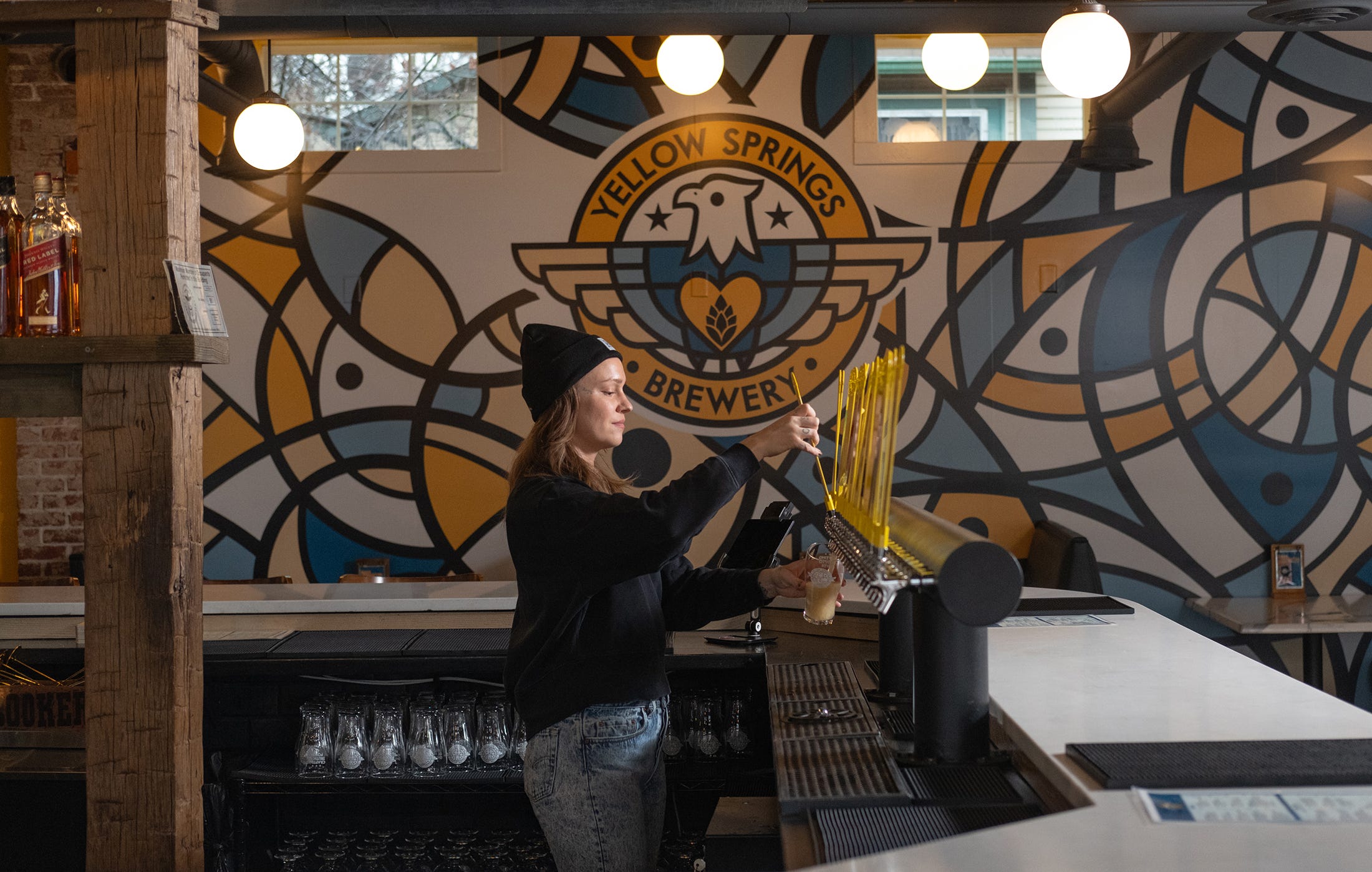 Faye Diebold pours a draft beer at Yellow Springs Brewery in Clintonville.