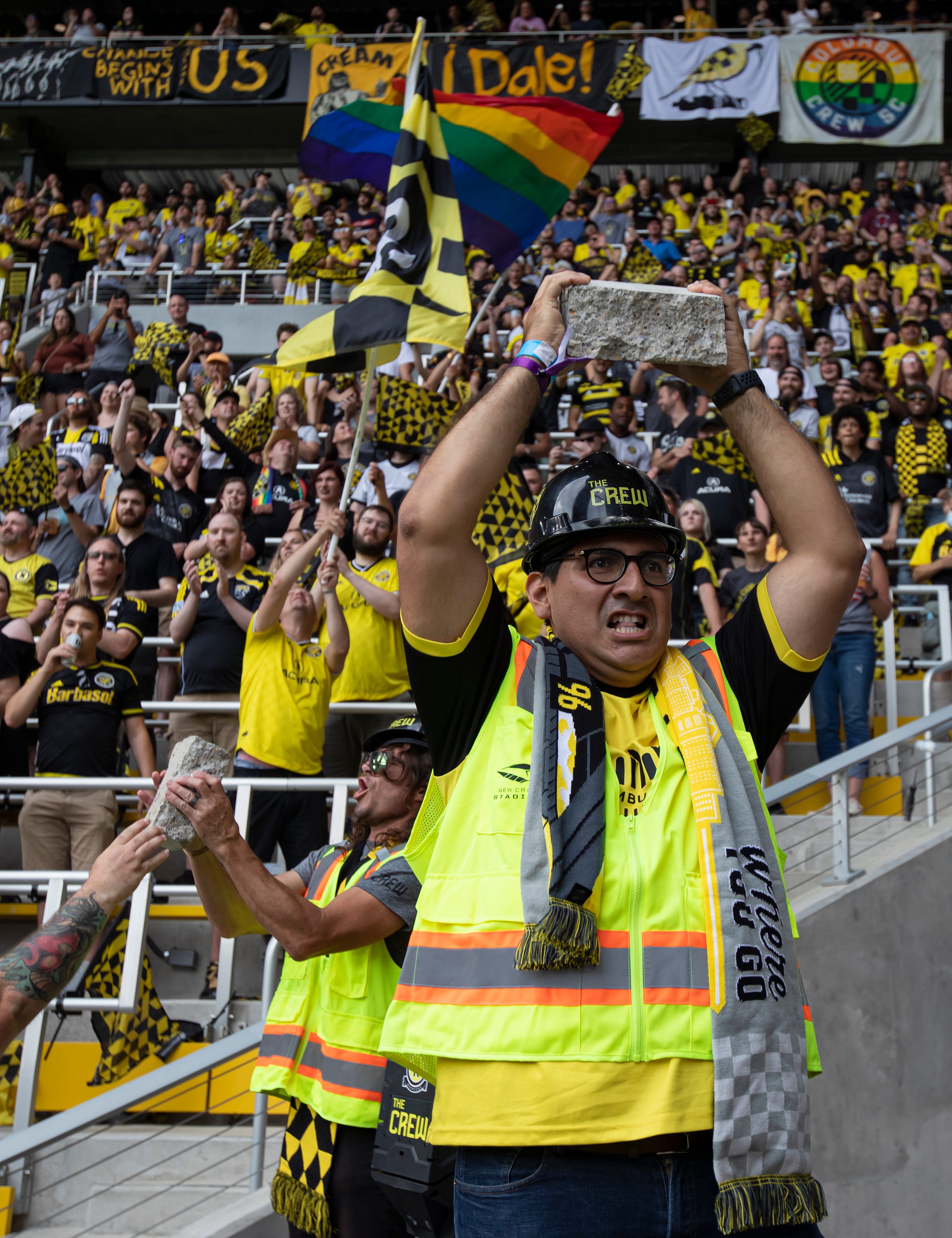 Jairo Manuel Alza hoists a piece of concrete over his head after a larger piece was broken with a jackhammer after the Columbus Crew scored a goal during the soccer game against the New England Revolution at Lower.com Field in Columbus, Ohio July 3.